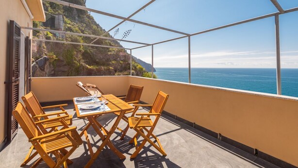A balcony with a table and chairs, overlooking a coastal landscape. - Queen of Sea Diamond, Terre Marine (Manarola)