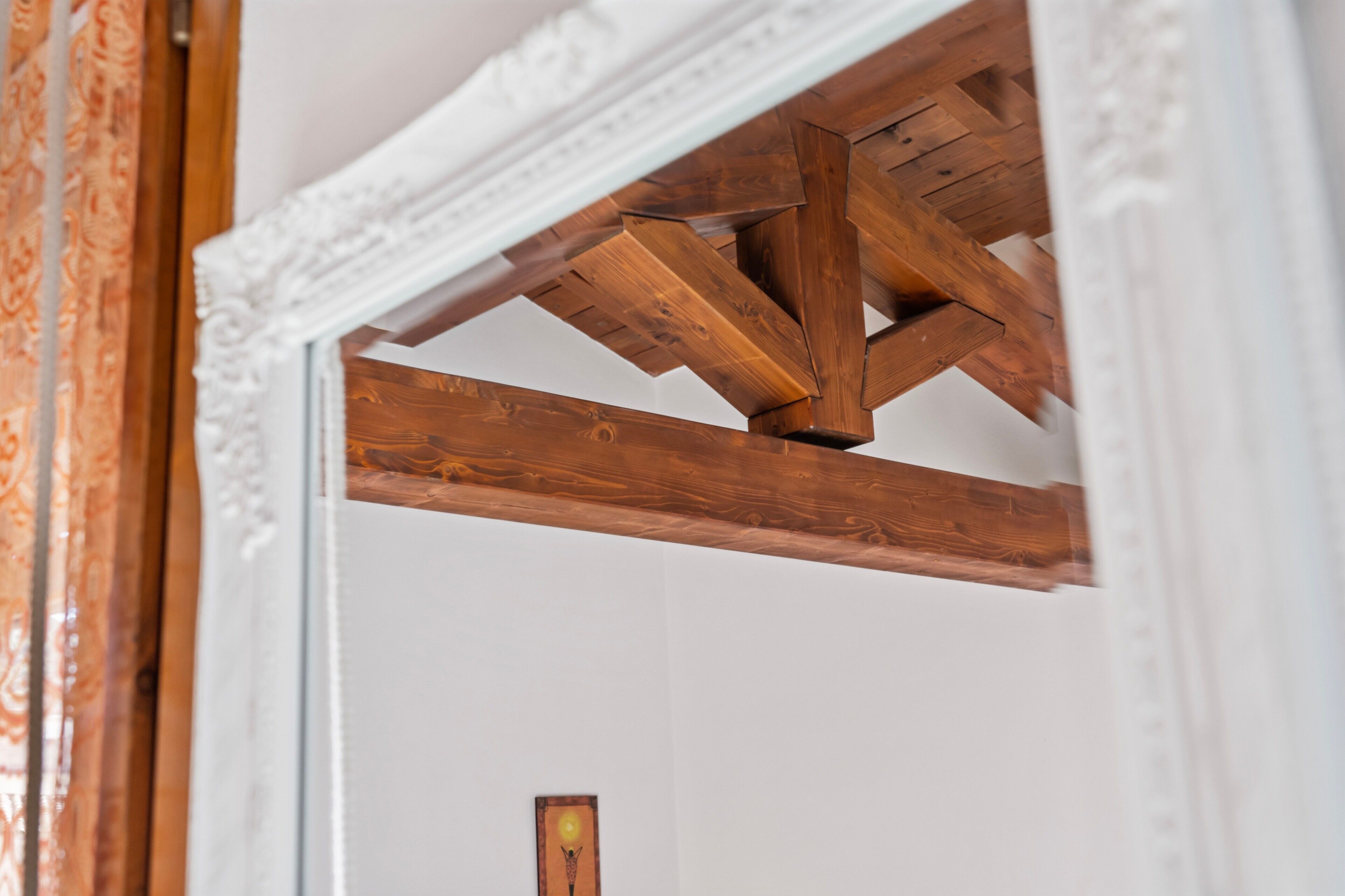 Struttura del soffitto in legno con modanatura decorativa bianca.
