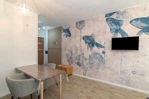 A dining area with a wooden table, chairs, and a wall mural of fish.