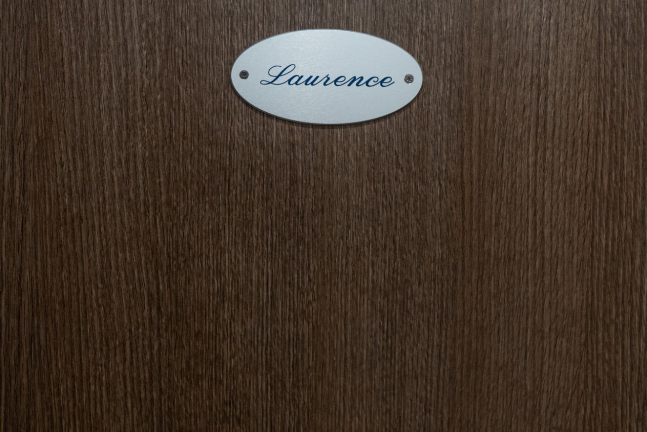 Una superficie de madera con una placa metálica que dice “Laurence”.