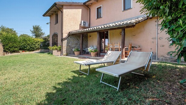 A house with a patio area featuring two lounge chairs. - Room 'Among the Olive Trees and the View' with Mountain Views, Private Garden, and Wi-Fi (Orvieto)
