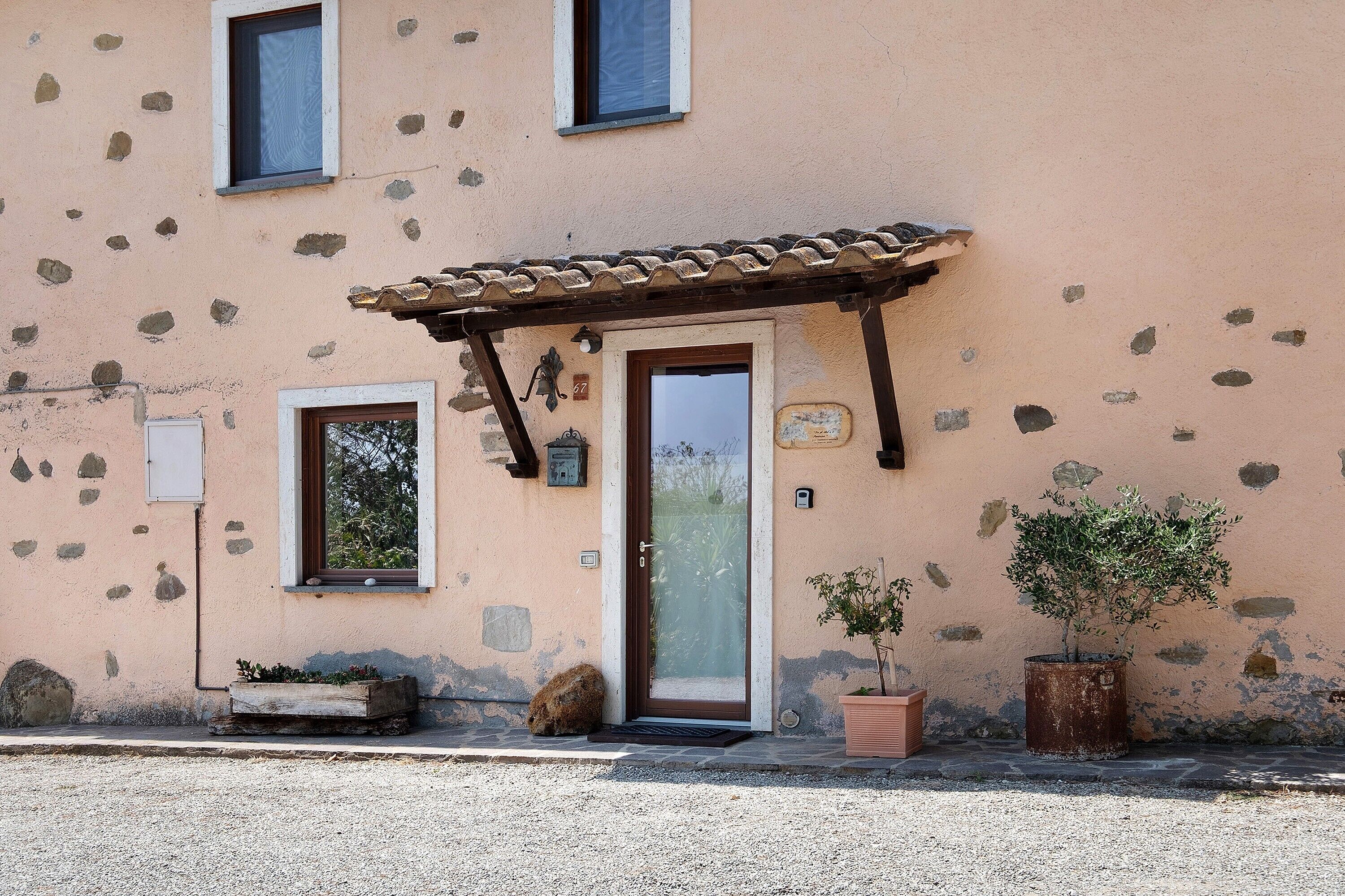 Un edificio con facciata in pietra, porta in legno e tetto in tegole.