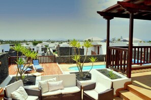 A rooftop terrace with a pool, outdoor seating, and a view of the surrounding buildings. - Vacation 'Casa Laura' with Heatable Pool, Sea View, Wi-Fi and Air Conditioning (Playa Blanca)