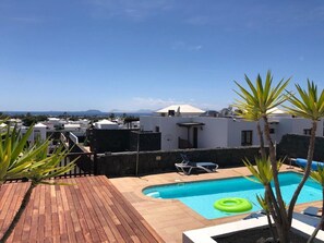 A rooftop pool with a clear view of the surrounding buildings and distant mountains. - Vacation 'Casa Laura' with Heatable Pool, Sea View, Wi-Fi and Air Conditioning (Playa Blanca)
