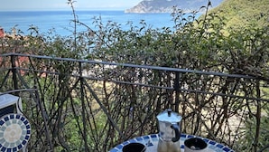 A terrace with a view of the sea, a table with two cups and a pot, and a mosaic table base. - Blue Stone, Marine Lands (Corniglia)