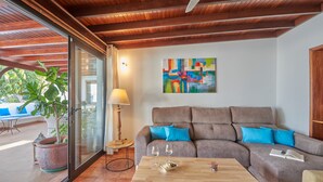 Un salon moderne avec un canapé, une table basse, une lampe et un tableau abstrait aux couleurs vives.