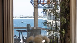 Un balcón con vistas al mar, una mesa y sillas.