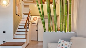 A staircase with wooden steps and a white wall. There is a door at the top of the stairs. - Magnolia, Welcome Way (Lerici)