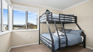 A bunk bed room with a window overlooking a landscape.