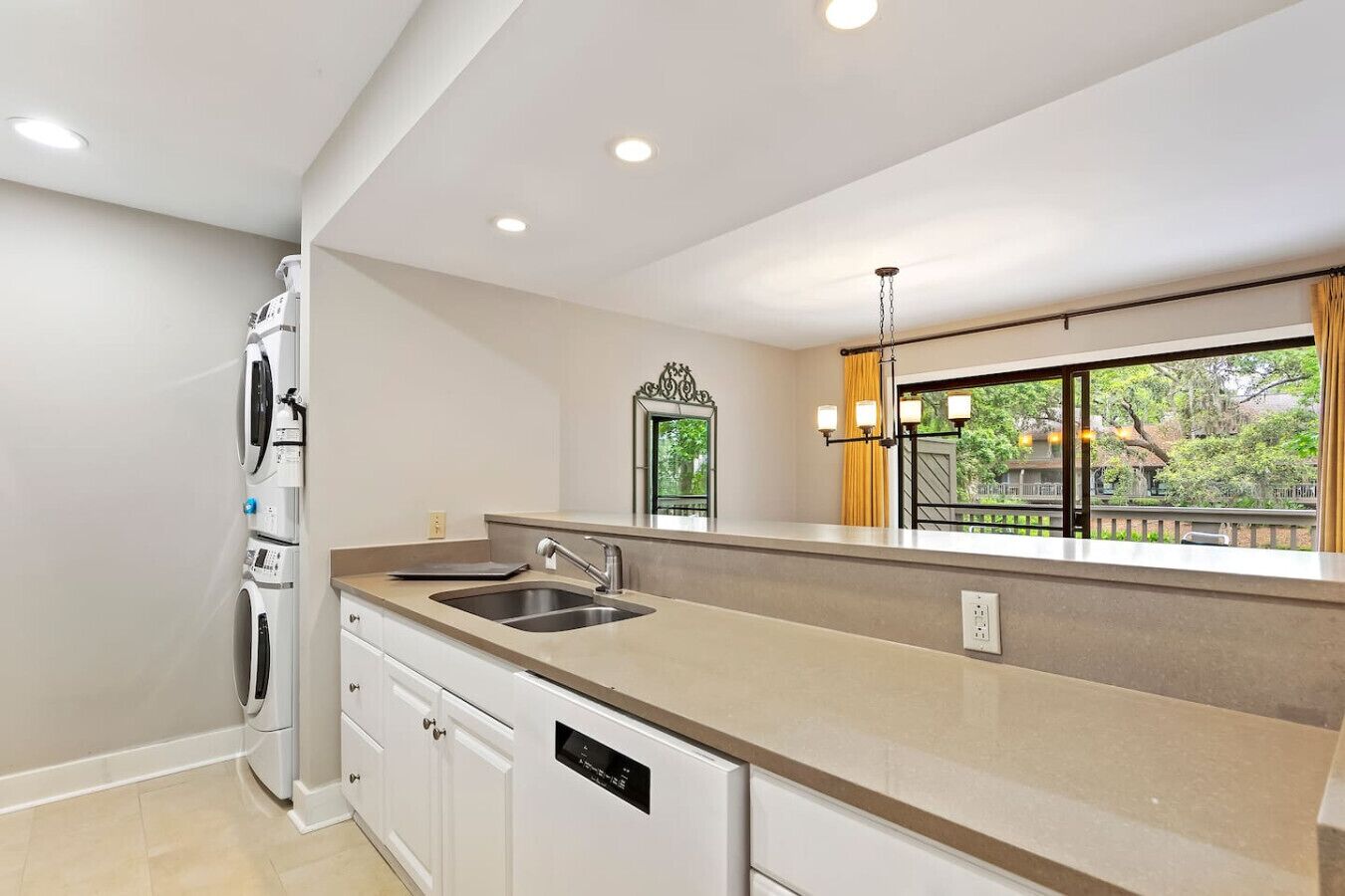 A modern kitchen with a large island, built-in appliances, and a view of the outdoors.
