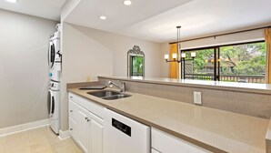 A modern kitchen with a large island, built-in appliances, and a view of the outdoors.