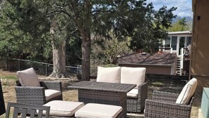Outdoor wicker furniture with cushions, a concrete patio, and a house in the background.