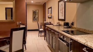 A hotel kitchen with a dining area, a coffee maker, and a microwave. - Raphael Suites (Sandton)