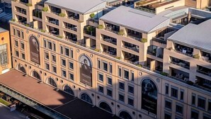 A multi-story hotel with a classic architectural design, featuring arched windows and balconies. - Raphael Suites (Sandton)