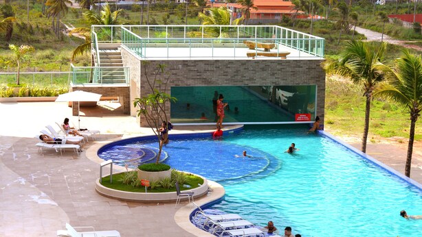 A swimming pool with lounge chairs and a water slide. - SaltBeach - Salinas Park Resort (Salinópolis)