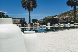 A pool area with lounge chairs, palm trees, and a clear sky. - Caesars Gardens Hotel & Spa - Adults Only (Rhodes)