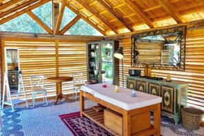 Un intérieur en bois comprenant une table à manger, des chaises, un miroir et une fenêtre.