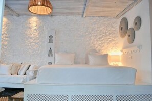A white-themed bedroom with a bed, a wall-mounted lamp, and a textured wall. - Caesars Gardens Hotel & Spa - Adults Only (Rhodes)