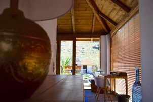 Una habitación con techo de madera, una mesa de comedor y vistas al exterior.