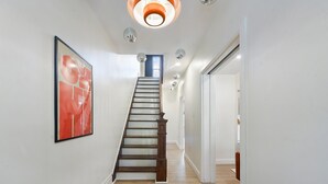 Un escalier avec des marches en bois et une rampe, menant à une pièce dotée d’une porte.