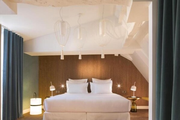 A modern hotel room with a large bed, wooden panel wall, and pendant lighting. - Hotel Dupond-Smith (Paris)