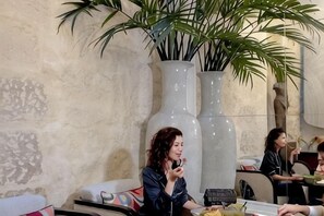 A dining area with a large vase, a sofa, and a table. - Hotel Dupond-Smith (Paris)