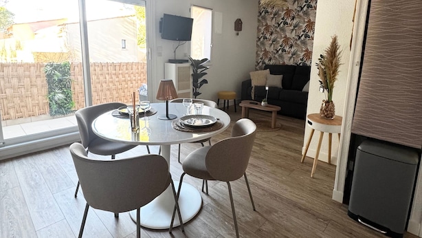 Una sala de estar moderna con comedor, ventanas grandes y chimenea.