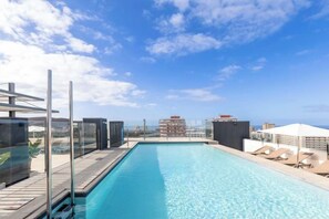 A rooftop pool with clear skies, lounge chairs, and a view of distant buildings. - Catalonia Oro Negro (Playa de las Americas)