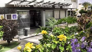 A hotel entrance with a sign reading 'HOTEL CATALONIA URBANO' and a visible handicap accessibility symbol.