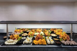 A buffet table with various food items and decorations. - Catalonia Oro Negro (Playa de las Americas)
