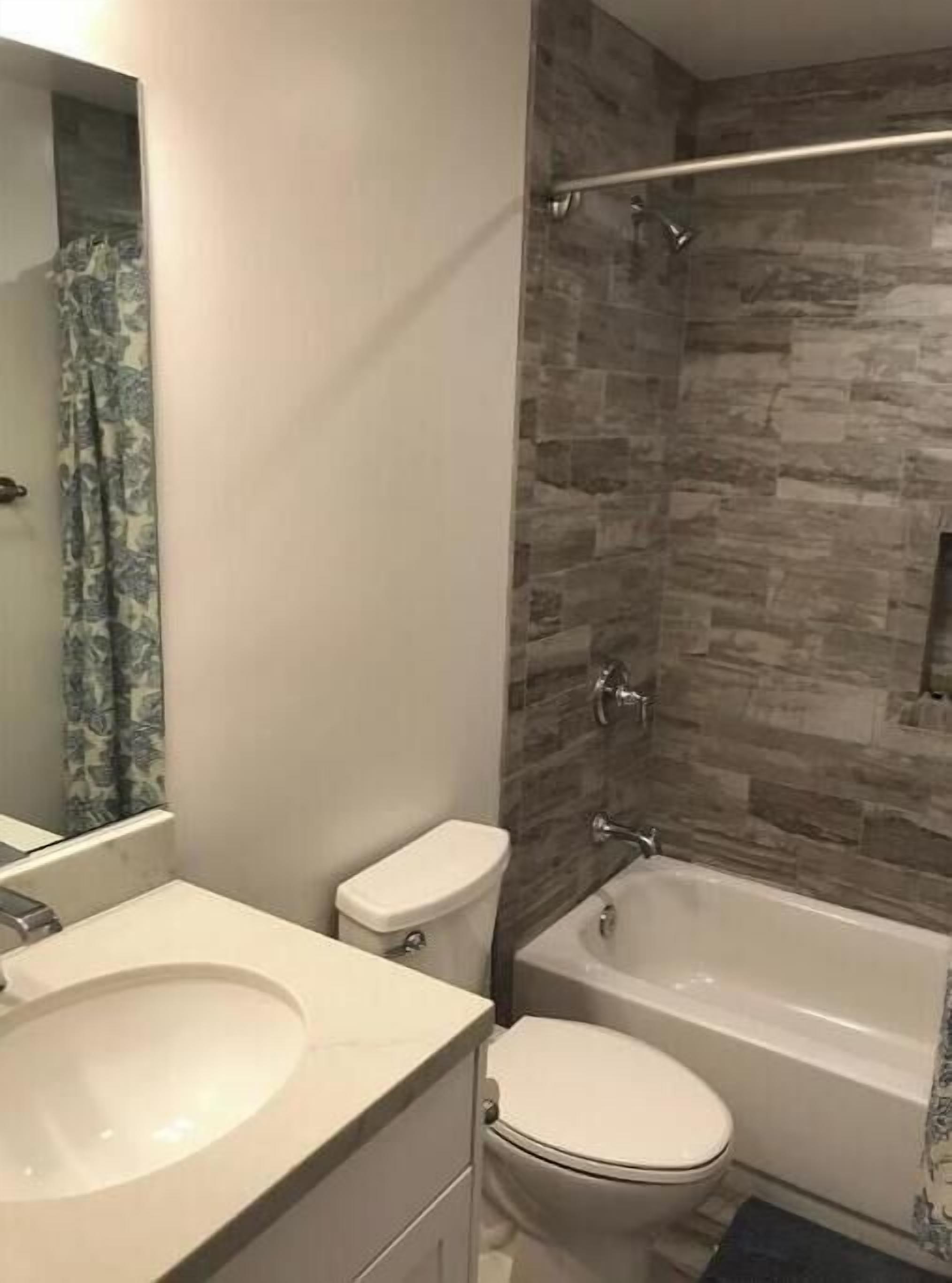 A bathroom with a sink, toilet, and bathtub.