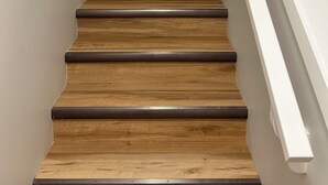 A wooden staircase with white handrails and a light-colored wall. - The Prairie Nest (Saskatoon)