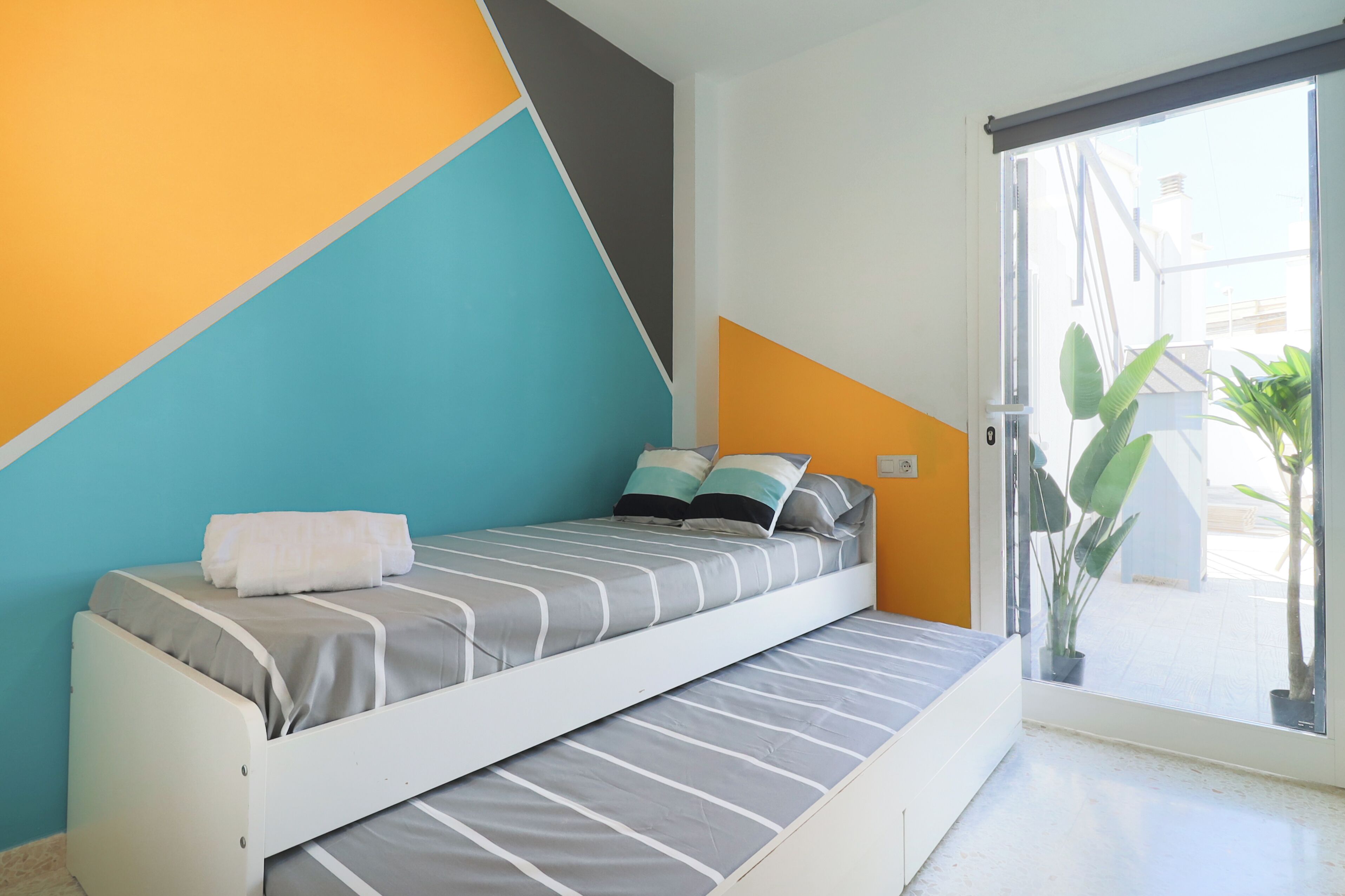 Un dormitorio moderno con una cama, un ventanal y vistas al exterior.
