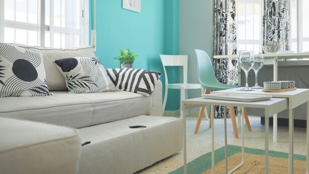 Una sala moderna con un sofá, una mesa de comedor y una silla.