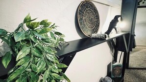 Una repisa negra con una planta en maceta, un plato decorativo y una mesita con un libro y un cuenco.