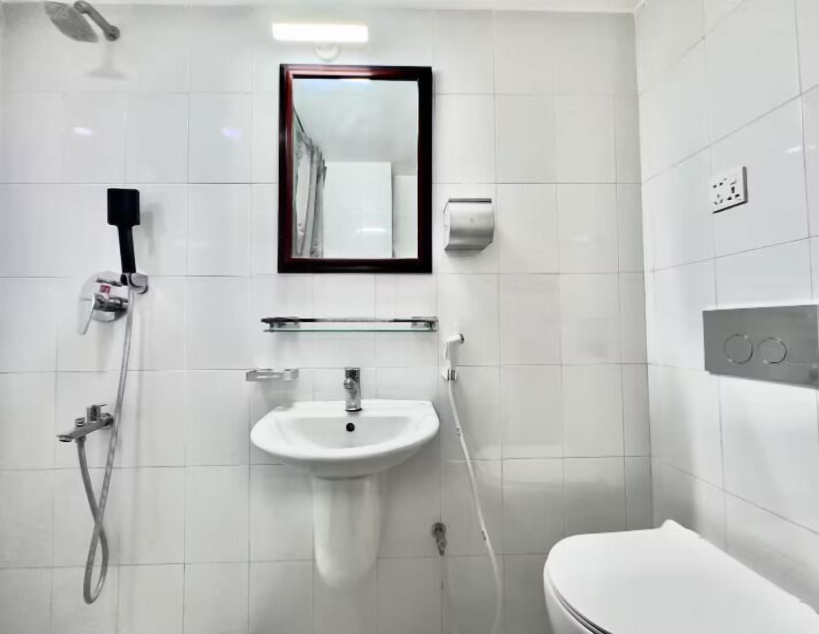 A modern bathroom with a white sink, a mirror, and a shower.