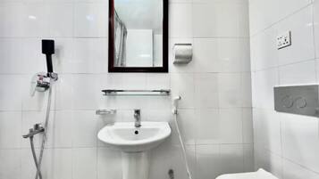 A modern bathroom with a white sink, a mirror, and a shower.