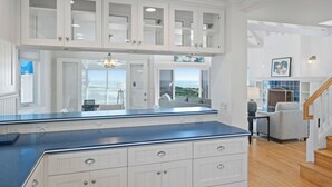 A kitchen with white cabinetry, a blue countertop, and a view of the outdoors.