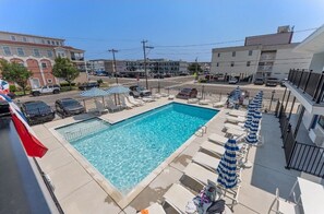 Relax by the rectangular pool surrounded by lounge chairs and umbrellas, offering a tranquil escape in the heart of the city.