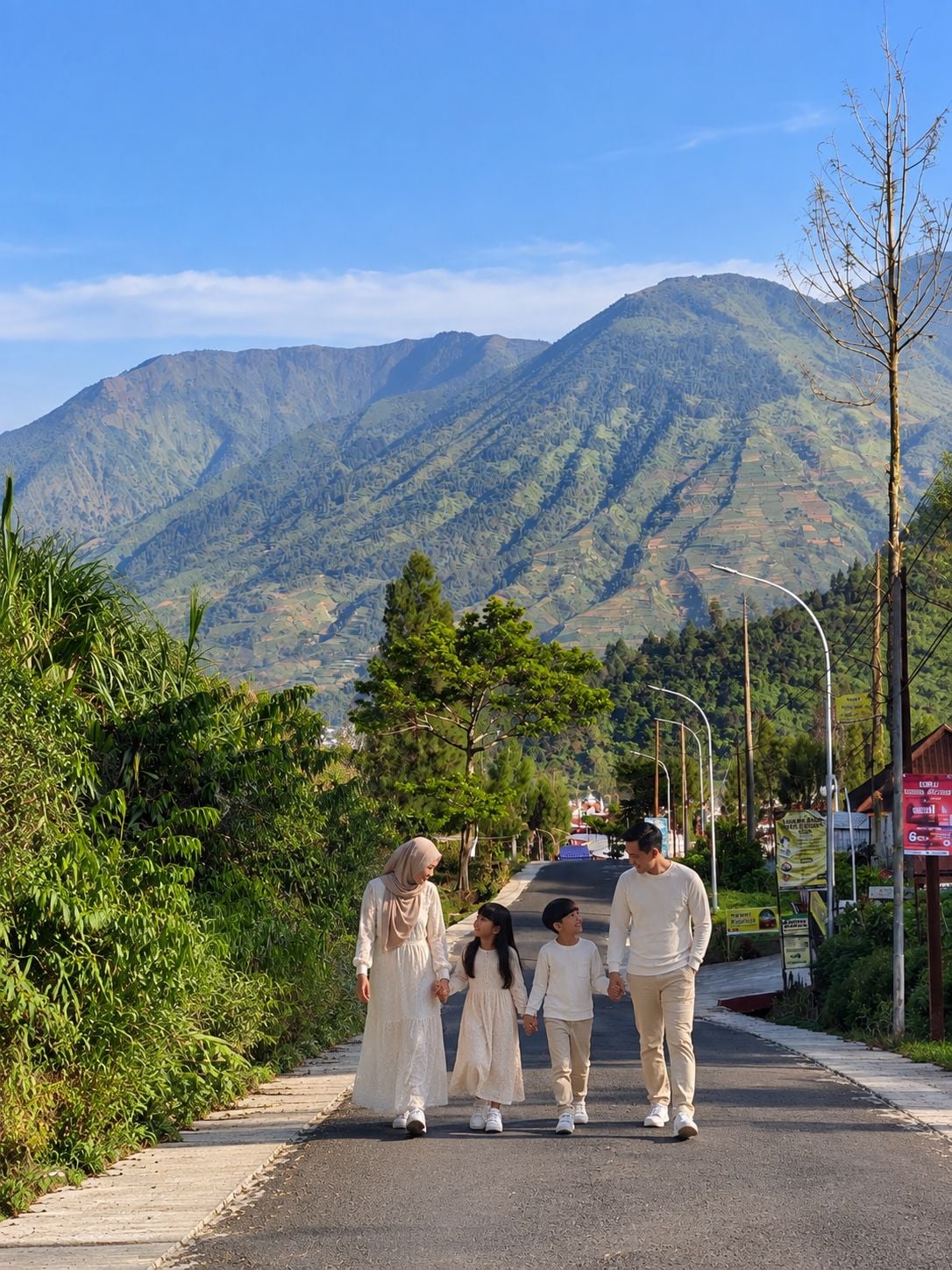 Una familia caminando por un camino pavimentado, con un paisaje montañoso al fondo.