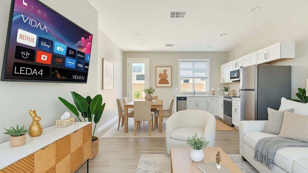 Una sala de estar moderna con televisor de pantalla plana, comedor y cocina.