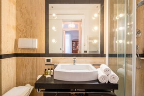 Un baño con un espejo grande, un lavabo y una ducha.
