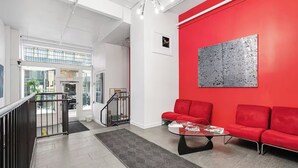 Un intérieur moderne avec un mur d’accent rouge, une table basse en verre et un canapé rouge.