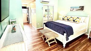 A bedroom with a bed, a ceiling fan, a dresser, and a hallway leading to another room. - Charming Canal Water View Townhome with Outdoor Pool, WiFi & AC in Ocean City (Ocean City)