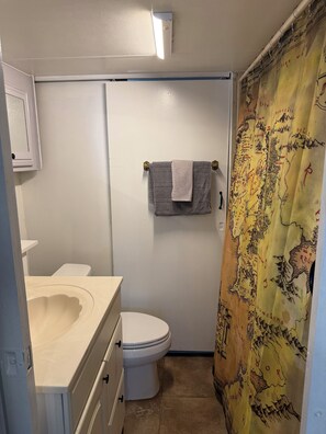 Une petite salle de bain comprenant des toilettes, un lavabo et un porte-serviettes.