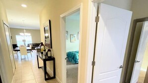 Un couloir donnant sur une salle à manger, un salon et une chambre.