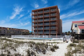 A multi-story hotel with a pool, surrounded by sandy beach and other buildings. - Buena Vista 305 | Beachfront | Beach Side Pool in Gulf Shores | My Beach Getaways (Gulf Shores)