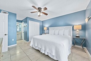 A bedroom with a large bed, a ceiling fan, two bedside lamps, and a nightstand. - Buena Vista 305 | Beachfront | Beach Side Pool in Gulf Shores | My Beach Getaways (Gulf Shores)