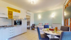 Een moderne keuken met een eethoek, inclusief een tafel gedekt met borden, glazen en een schaal fruit.