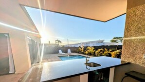 A modern kitchen with a built-in sink and a view of a pool area. - New Sunset Villa w/Private Pool - Casa Linda (Sosúa)